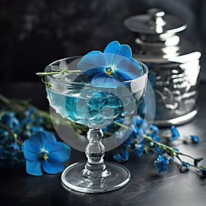 Bright blue cocktail in a nick and crystal glass garnished with a flower