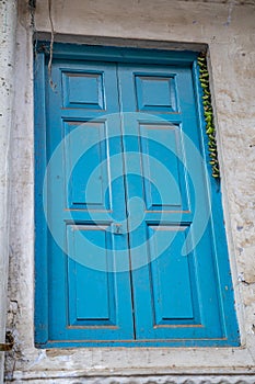 Bright blue door in an alley in Old Delhi India. Green chillies tied on a thread hanging to keep away Alakshmi, or Jyestha