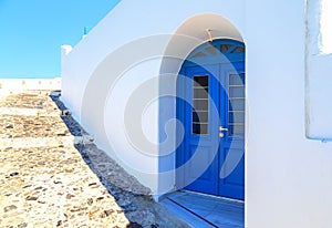 Bright blue doors, shutters and perfect white washed walls in the back streets of fira, Santorini, Greece.