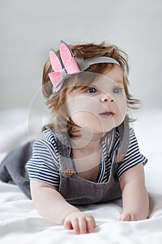 Bright blue eyed beauity 6 month old baby girl looks closely at the camera