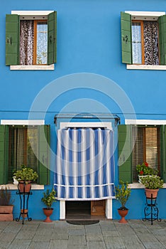 Bright blue facade of a house on the island of Burano in Italy.