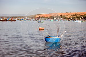 Bright blue fishing basket boat with a wooden oar, landing net, and night lights