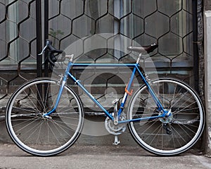 Bright blue Fixed Gear beautiful vintage bicycle stands on the street. Hipster.