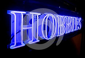 A bright blue HOBBIES neon sign