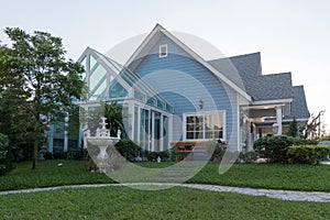 Bright blue house in sunlght with colorful poppies and some graceful trees.,with glass room.