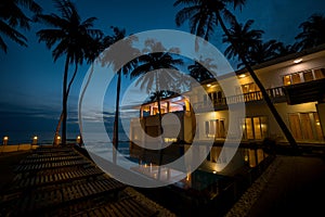 Bright blue pool and courtyard of a resort at night time in Vietnam