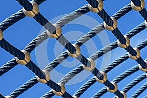 Bright blue rope mesh against a bright blue sky close-up. Background and texture