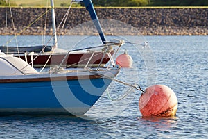 Bright blue sailing boat on a mooring ball