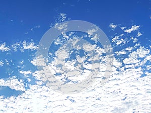 Bright blue sky covered by dense altocumulus clouds pattern background.