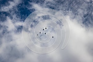 Bright blue sky with jet fighter formation flying