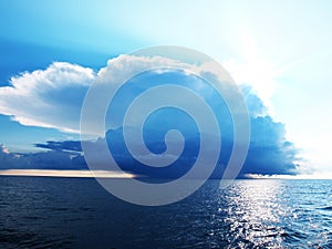 Bright blue sky with stormy clouds over a sea