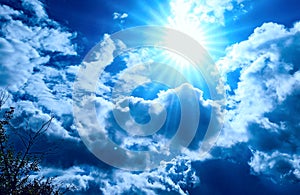 Bright blue Solar sky background with white clouds and sun.