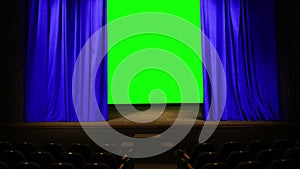 a bright blue theatrical curtain in the auditorium moves to the sides behind it a green background