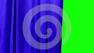 A bright blue theatrical curtain moves apart to the left side behind it is a green background