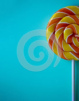 Bright blue vertical background with half swirl lollipop with copy space