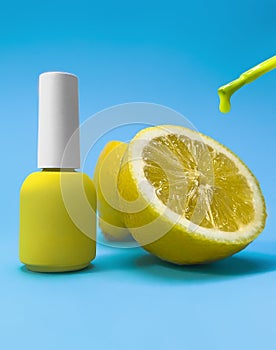 Bright bottle of nail polish on a blue background with lemon fruits