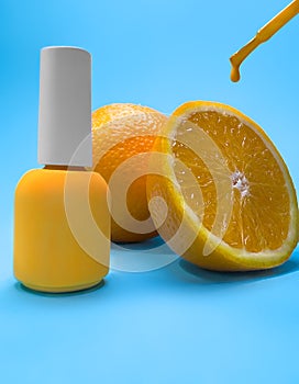 Bright bottle of nail polish on a blue background with orange fruits