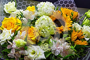 Bright bouquet with yellow sunflowers and rose, pink eustoma and green viburnum floral background