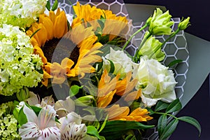 Bright bouquet with yellow sunflowers and rose, pink eustoma and green viburnum floral background