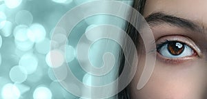 Bright and captivating eye with a unique reflection in a blurred background of sparkling lights