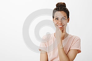 Bright charismatic and happy attractive woman with clear perfect skin smiling broadly holding hand on chin and gazing