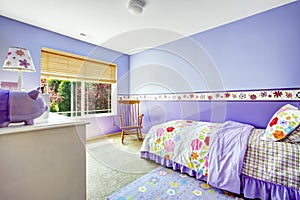 Bright cheerful bedroom in purple color with colorful bedding