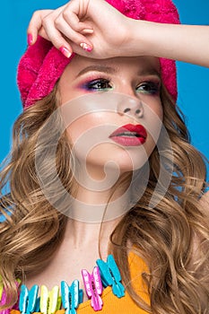 Bright cheerful girl in home hat, colorful make-up, curls and pink manicure. Beauty face.