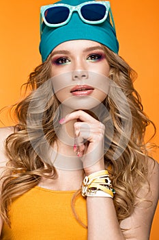 Bright cheerful girl in sports hat, colorful make-up, curls and pink manicure. Beauty face.