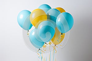 Bright and cheerful yellow and blue balloon floating gracefully on a clean white background