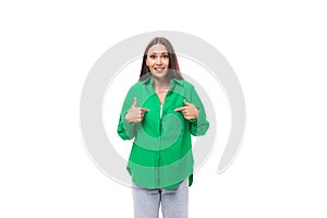 bright cheerful young brown-haired female model with brown eyes in a green shirt posing on a white background with copy