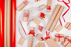 Bright christmas background - festive present boxes with red ribbons, labels, rolls paper as decorative holiday pattern on white.