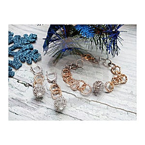 Bright Christmas decorations on a festive background. A graceful bracelet and unusual earrings with a large chain.