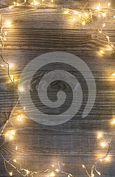 Bright Christmas lights sorrounding wooden background