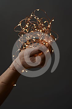 Bright christmas lights in woman`s hands