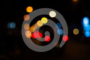 Bright circles from streetlamps on defocused photo of night stre