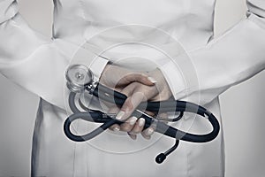 Bright close up of female doctor with stethoscope in her hands.