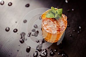 Bright cocktail with mint leaves and an orange slice