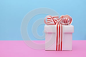 Bright color gift box on pink and blue background.