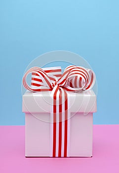 Bright color gift box on pink and blue background.