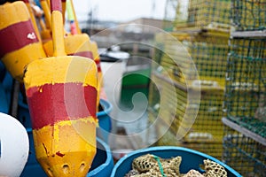 Bright colored buoys in selective focus alongside other equipment and crab traps in port1