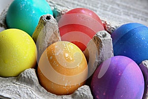 Bright colored Easter eggs in an egg carton
