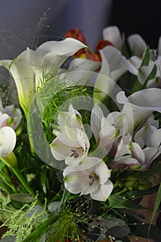 Beautiful bouquets in jars, glass glasses, bottles placed on a yellow wooden table.