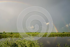 A bright colorful double rainbow over the dutch countryside near Gouda, Holland.