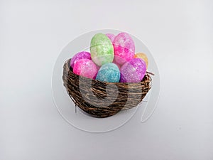 Bright colorful Easter eggs in a twig birds nest isolated on a white background