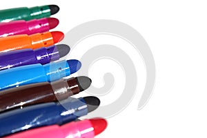 Bright colorful multicolored markers lie on a white background.