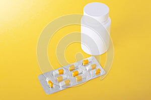 A bright colorful of painkillers, antibiotics whith medicine bottle for vitamins on a bright yellow background.