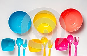 Bright colorful plastic disposable tableware on white background