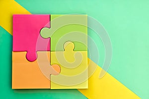 colorful stickers for notes in form of puzzles. multicolored square sheets of paper pasted on turquoise background copy space.