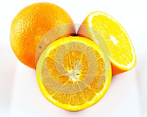 Two whole and halved oranges on white.