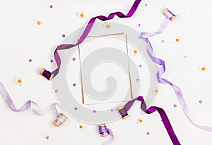 Bright composition with silk ribbons, chamomile, sequins and crystal on a white background. Space for a greeting text